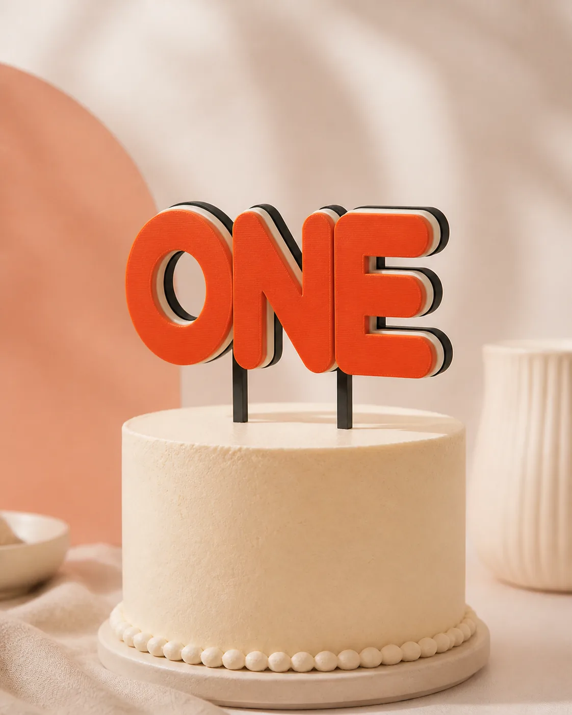 Orange layered ONE cake topper on a minimalist cream birthday cake